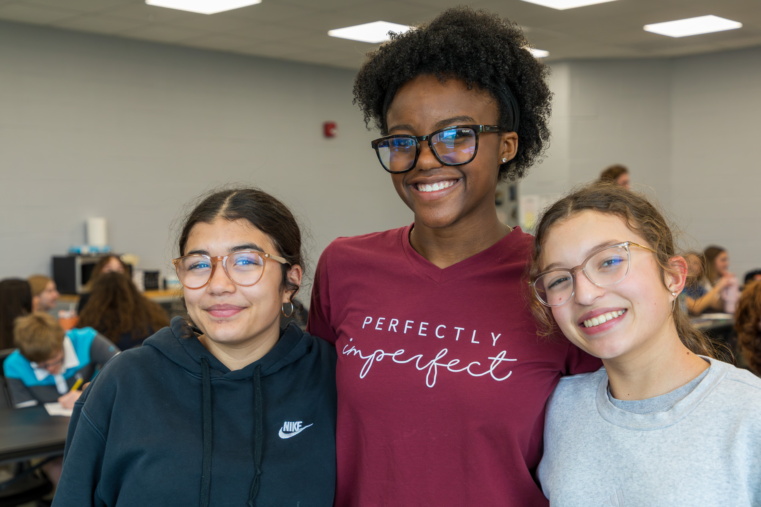 Three smiling girls in classroom